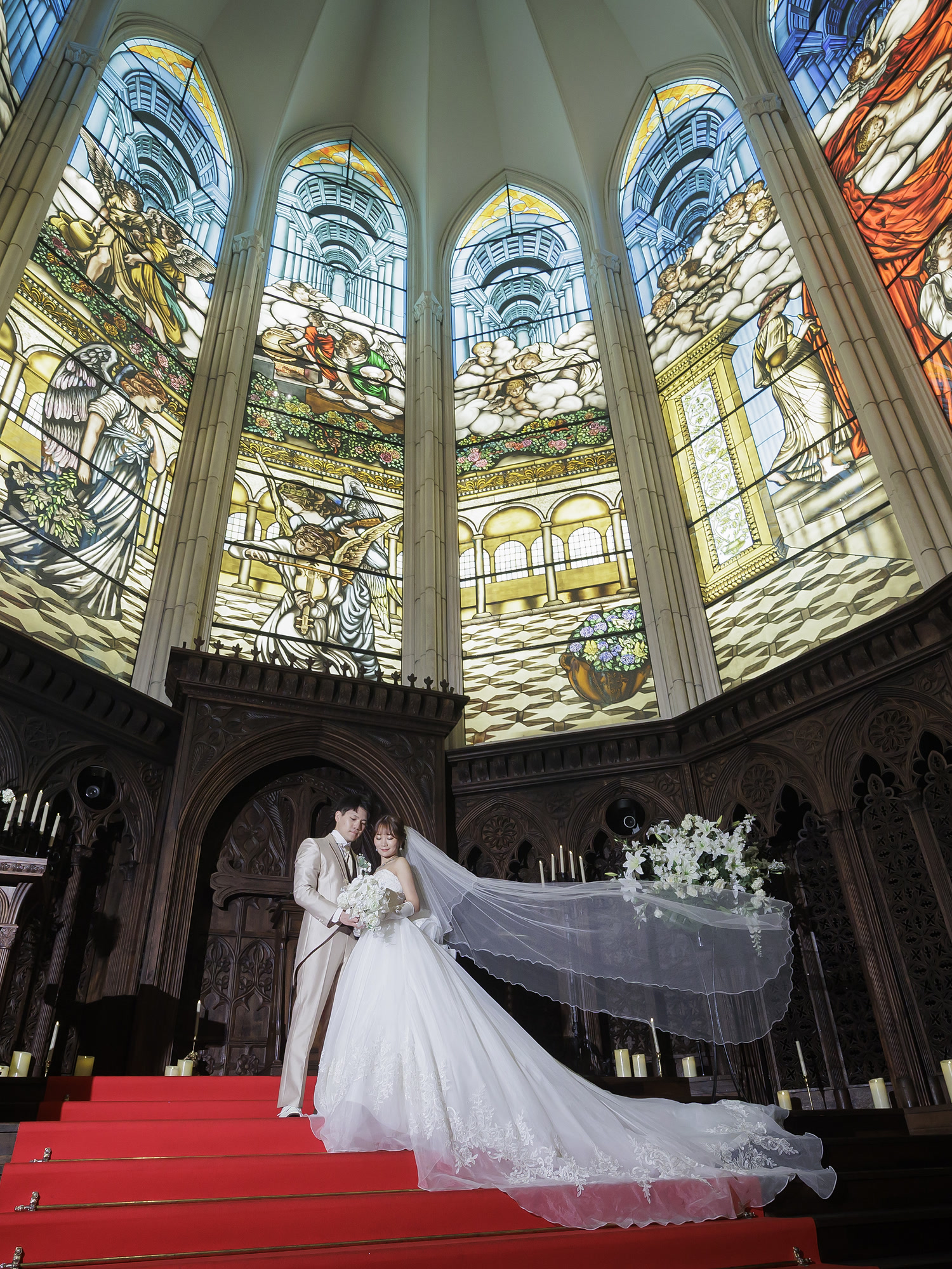 Bride on the chapel aisle beneath stained glass on her wedding day in Japan