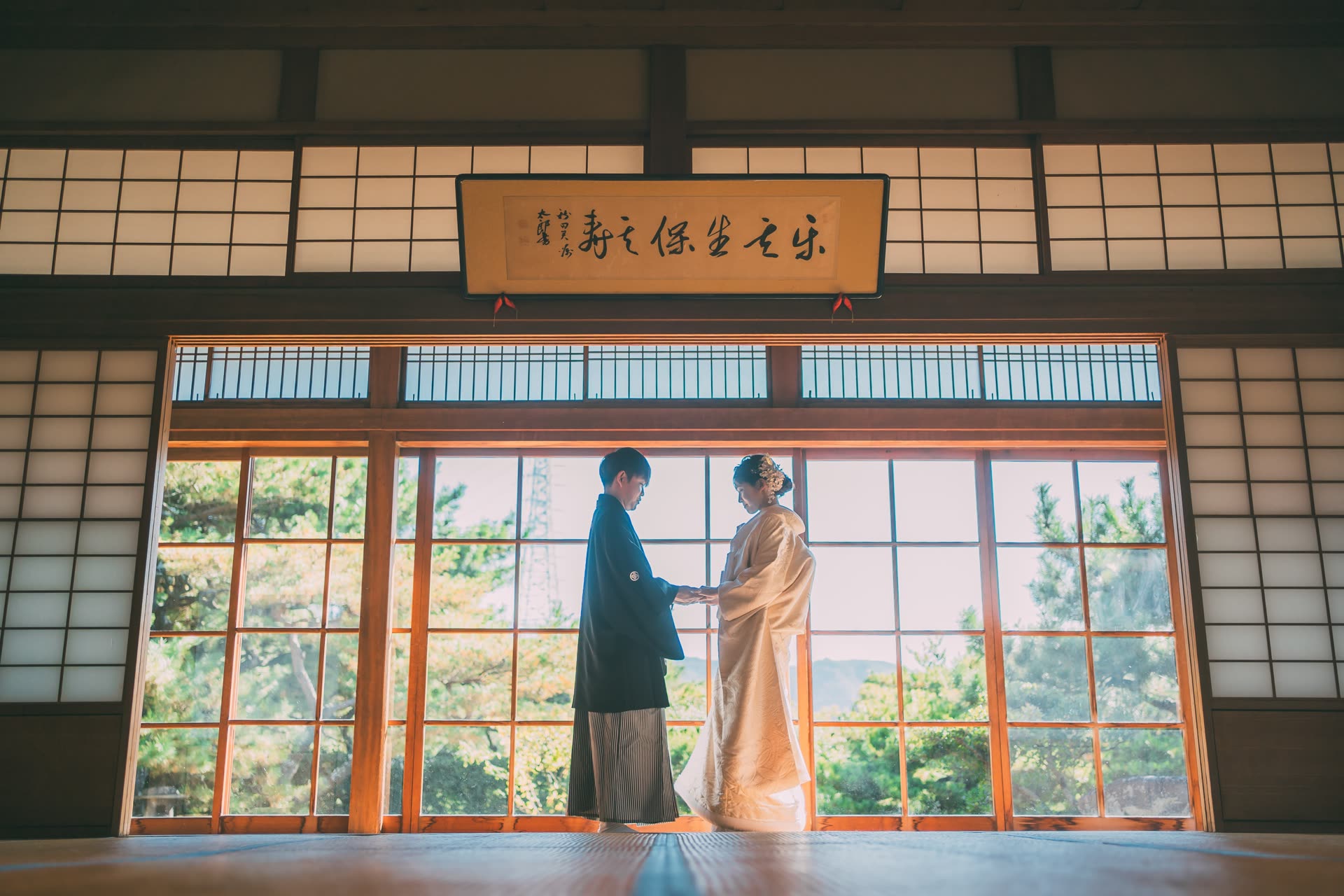 和服新人在鋪有榻榻米的和室中相對而立,背景為障子門的日本婚紗攝影