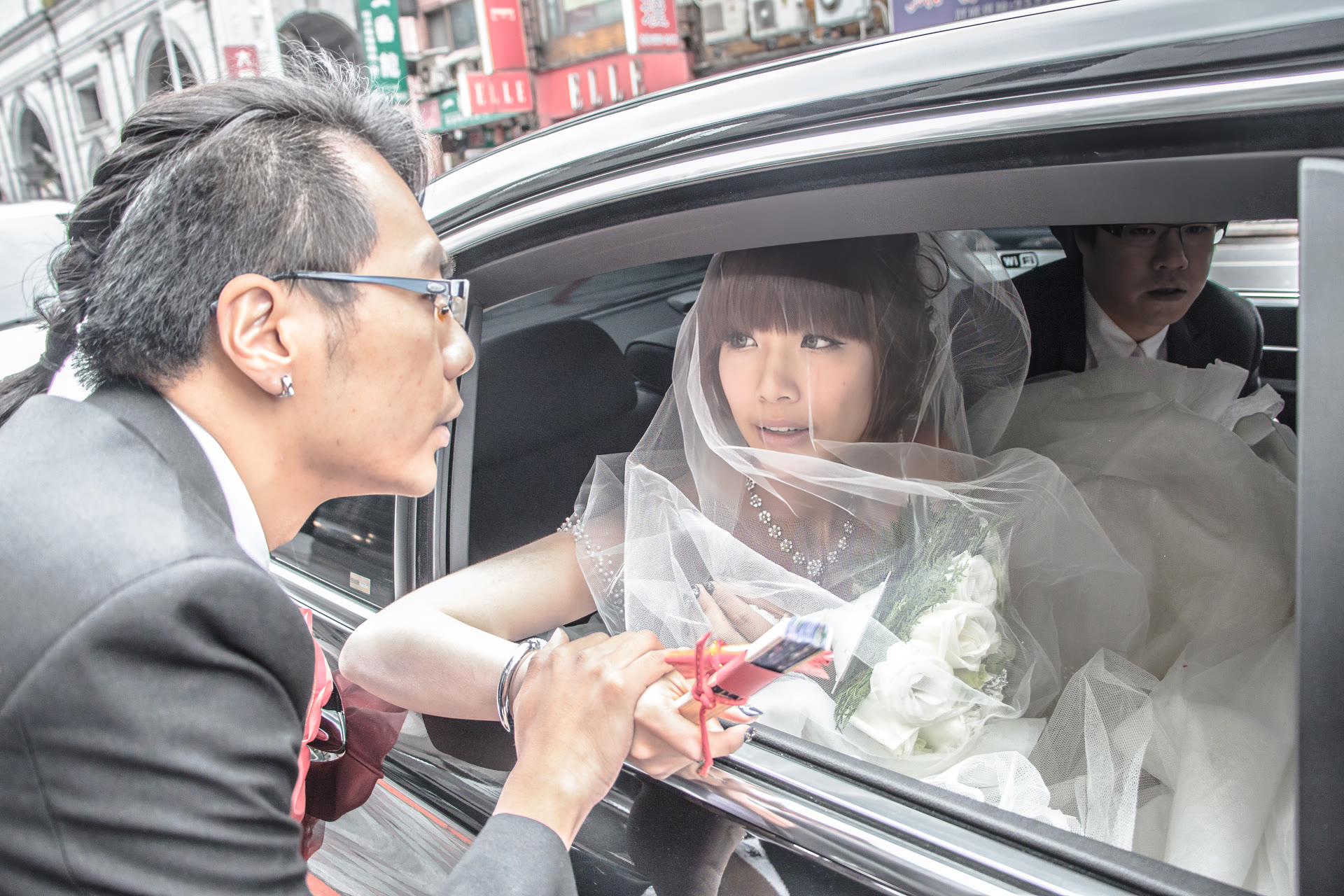 婚禮當天,新娘坐在車內,自敞開的車窗向外望