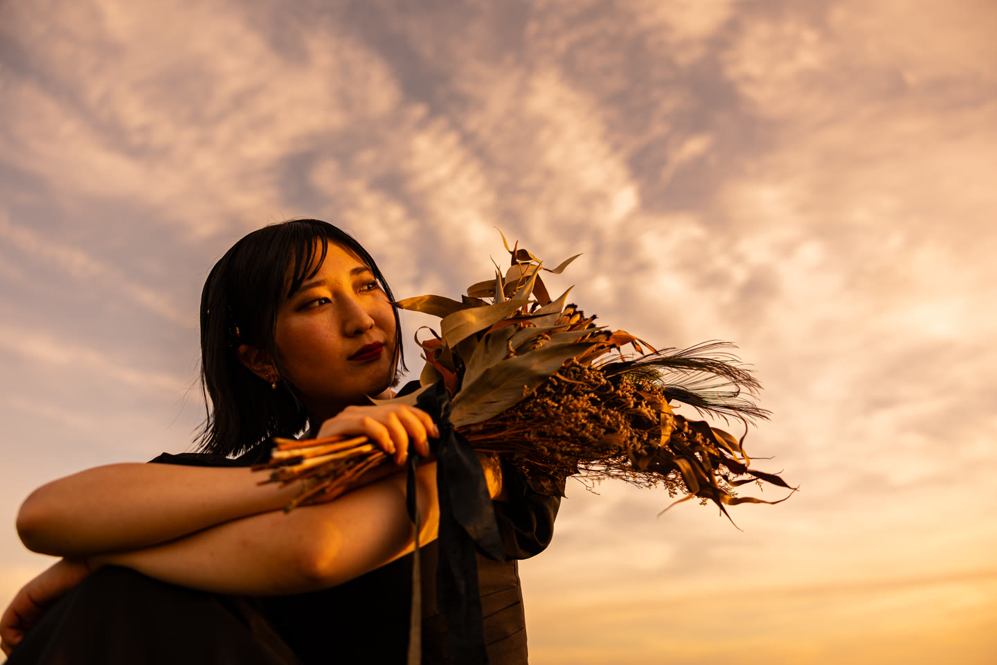 傍晚的光線中，手拿捧花的沖繩新娘