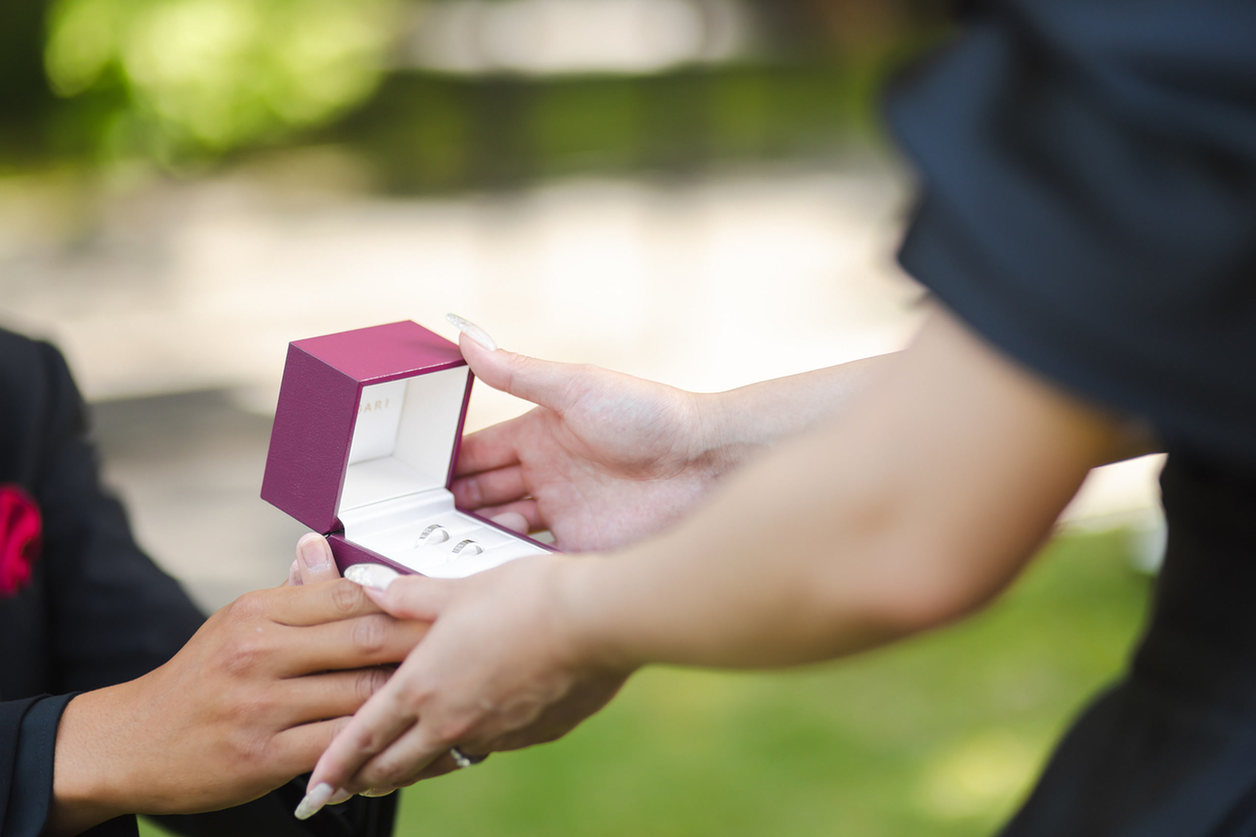 Hands presenting an open ring box during a proposal photoshoot in Japan
