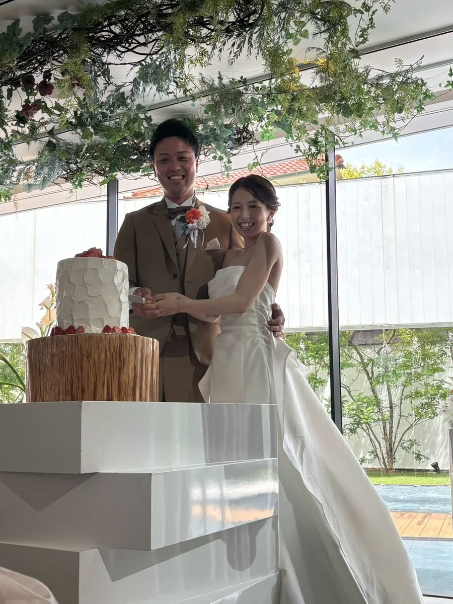 新人在綠意垂吊的天花板下切結婚蛋糕