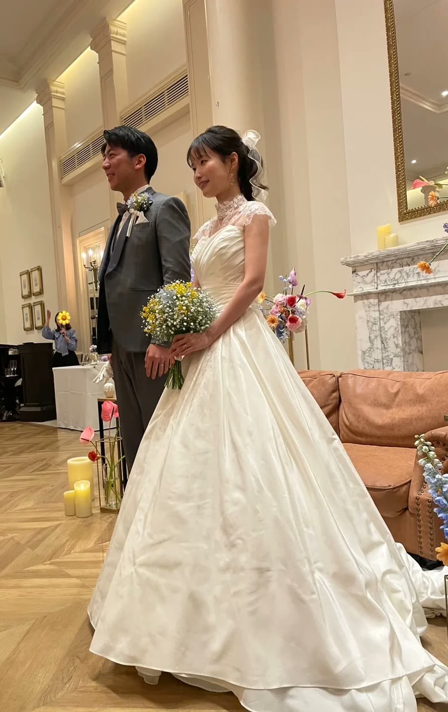 新娘手持黃白色捧花,站在新郎身旁