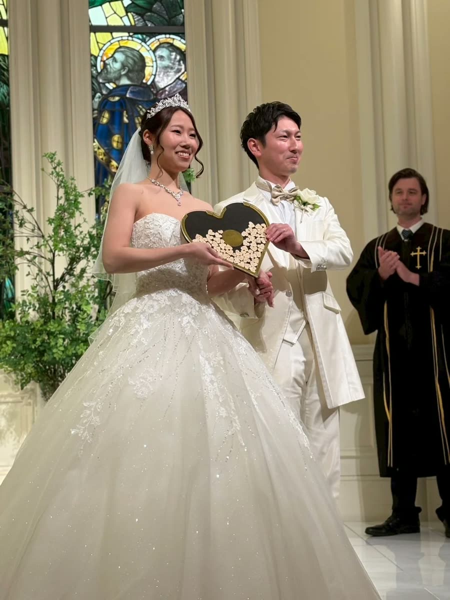 白色禮服的新人在教堂內與證婚人一起歡笑